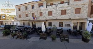 Hotel Los Conejos في Mora: مطعم فيه طاولات وكراسي امام مبنى