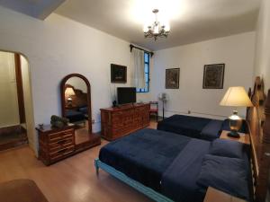a bedroom with two beds and a dresser and a mirror at Home Sweet Home in Cuernavaca