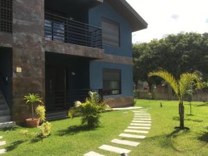 加羅帕巴的住宿－Garopaba- Gamboa liris Veneranda，一座棕榈树的蓝色房子