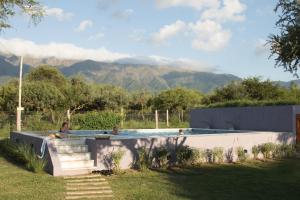 a pool with people in it with mountains in the background at Posada del Manzano in Carpintería