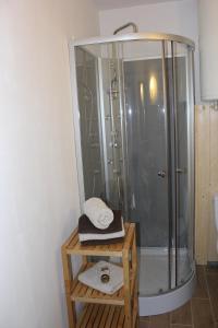 a bathroom with a shower and a table with a mirror at Studio tout confort au calme in La Bresse