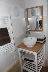 y baño con lavabo blanco y espejo. en Studio tout confort au calme en La Bresse