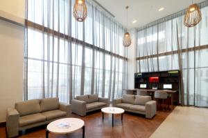 a living room with couches and tables and large windows at Holiday Inn & Suites - Monterrey Apodaca Zona Airport, an IHG Hotel in Monterrey