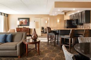 a hotel living room with a couch and a kitchen at Holiday Inn Hotel & Suites Des Moines-Northwest, an IHG Hotel in Urbandale