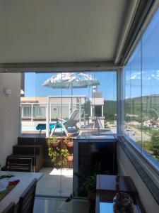 a view of a patio with an umbrella and a pool at Linda Cobertura com Piscina - Conforto e Sofisticação! in Bombinhas