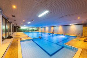 a large swimming pool in a large building at Vakantiepark Wilhelm Tell Superieur Chalet in Opglabbeek