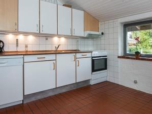 une cuisine vide avec des placards blancs et une fenêtre dans l'établissement 6 person holiday home in Hejls, à Hejls