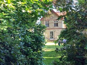 stary dom przez drzewa na podwórku w obiekcie 10 person holiday home in S nderborg w mieście Sønderborg