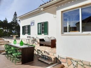 a patio with a table and chairs next to a house at casal do melro in Ericeira