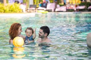
a woman and a child playing in a pool at Holiday Ao Nang Beach Resort, Krabi - SHA Extra Plus Certified in Ao Nang Beach
