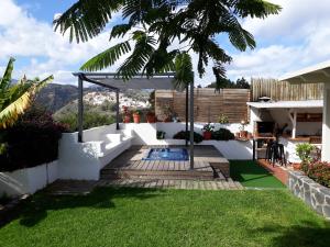 a backyard with a pool and a pergola at Casa cueva Bandama con jacuzzi in Tafira