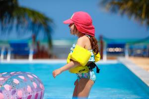 a young girl is in the water at a pool at Sollaris Ecopousada in Japaratinga