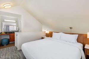 a bedroom with a large white bed and a window at Clementine Hotel & Suites Anaheim in Anaheim
