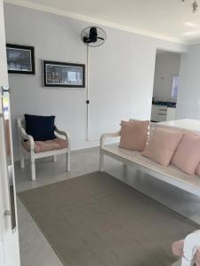 a living room with a couch and two chairs at Morada da Praia - Casa in Bertioga