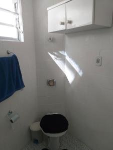 La salle de bains est pourvue de toilettes noires et d'une fenêtre. dans l'établissement Apartamento Carrinho do Kuko n 309, à Praia Grande