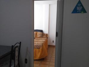 une porte menant à une chambre avec un lit. dans l'établissement Apartamento Carrinho do Kuko n 309, à Praia Grande