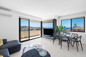 uma sala de estar com mesa e cadeiras em Coogee Dream View Apartment em Sydney