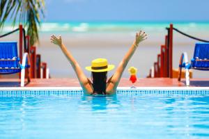 a woman in a swimming pool with her arms in the air at Sollaris Ecopousada in Japaratinga