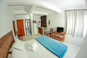 Un dormitorio con una cama con una manta azul. en Pousada Águas de Bombinhas, en Bombinhas