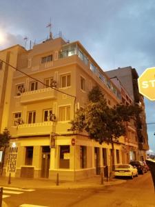 un edificio amarillo en la esquina de una calle en Alcaravaneras Hostel en Las Palmas de Gran Canaria