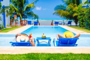 two people laying on chairs in the pool at a resort at Sollaris Ecopousada in Japaratinga