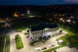 un grand bâtiment blanc avec un parking la nuit dans l'établissement Holiday Inn Express & Suites Van Buren-Fort Smith Area, an IHG Hotel, à Van Buren