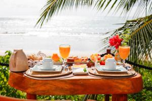 a table with food and drinks on the beach at Sollaris Ecopousada in Japaratinga