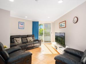 sala de estar con sofá y TV de pantalla plana en Bay Apartments Unit 10 en Gold Coast