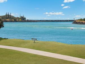 
a park bench overlooking a body of water at 5/18 Endeavour Parade - Riverfront Tweed Heads in Tweed Heads
