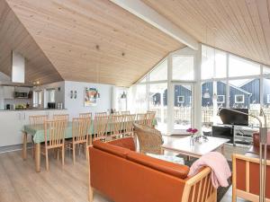 uma sala de estar com um sofá, uma mesa e cadeiras em Five-Bedroom Holiday home in Millinge em Millinge