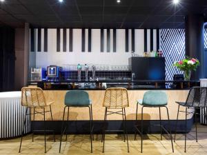 un bar avec trois chaises et un comptoir dans l'établissement ibis Styles Massy Opéra, à Massy