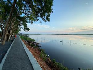 um caminho ao lado de um grande corpo de água em Chuanchom Resort em Phatthalung