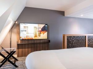 Телевизор и/или развлекательный центр в Novotel Deauville Plage