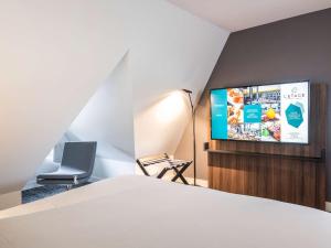 Телевизор и/или развлекательный центр в Novotel Deauville Plage
