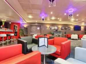 a restaurant with red chairs and a table at ibis Styles Paris Roissy-CDG in Roissy-en-France