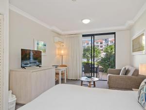 a bedroom with a bed and a living room at Calypso Plaza Resort Unit 141 in Gold Coast