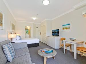 a hotel room with a bed and a couch and a table at Calypso Plaza Resort Unit 141 in Gold Coast
