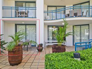a building with potted plants in a courtyard at Calypso Plaza Resort Unit 141 Studio style apartment - Beachfront Coolangatta in Gold Coast