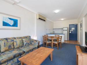 ein Wohnzimmer mit Sofa und Tisch in der Unterkunft Calypso Plaza Resort Unit 146 in Gold Coast