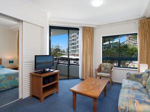 a living room with a television and a couch and a table at Calypso Plaza Resort Unit 146 in Gold Coast