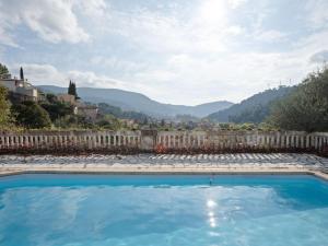 a swimming pool with a fence and mountains in the background at Quiet house in Drap with swimming pool in Drap