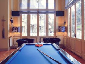 una sala de billar con una mesa de billar con pelotas. en Hôtel Mercure Saint-Nectaire Spa & Bien-être en Saint-Nectaire