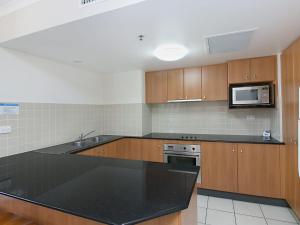 a kitchen with a black counter top and a microwave at Calypso Tower Unit 807 in Gold Coast