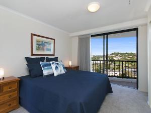 a bedroom with a blue bed and a balcony at Calypso Tower Unit 807 in Gold Coast