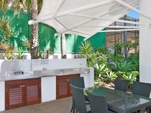 a patio with a table and chairs under a white umbrella at Calypso Tower Unit 807 in Gold Coast
