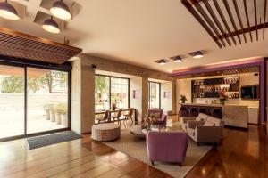 a living room with purple chairs and a table at Mercure Bogota BH Retiro in Bogotá