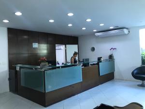 a woman standing at a reception desk in a office at Boulevard Riviera Flat - VISTA MAR E CLUBE in Riviera de São Lourenço +18 photos