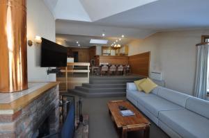 a living room with a blue couch and a fireplace at Salzburg Apartments in Perisher Valley