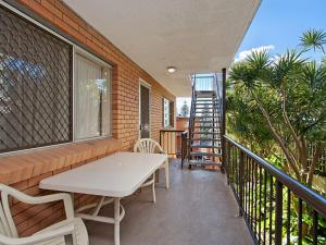 a balcony with a table and chairs and a ladder at Como Unit 5 in Gold Coast