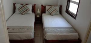two twin beds in a small room with a window at Hickory Penang Hill in George Town